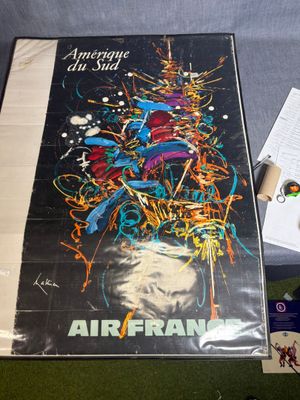 une affiche d'Air France posée sur une table, à côté d'une paire de chaussures