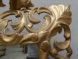 a gold mirror with a bird on top of it