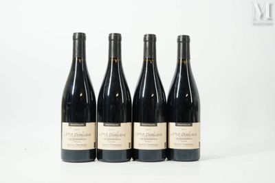four bottles of wine are lined up on a white surface