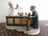 a figurine of a woman and a boy with a scale on a table