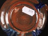 a brown and blue vase with a tag on it