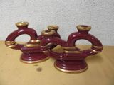 trois vases rouges et dorés posés sur une table
