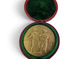 l'image d'une médaille d'or dans un écrin rouge sur fond blanc