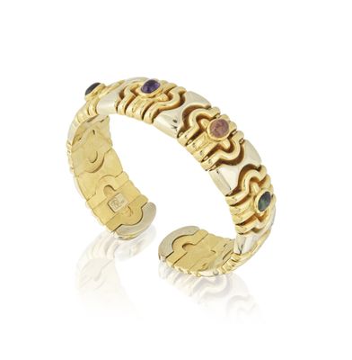 un gros plan d'une bague en or sertie de pierres de différentes couleurs