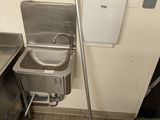 un lavabo en métal et une serpillière bleue dans des toilettes publiques