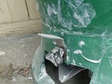 an image of a green trash can with a hole in it