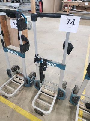 Deux diables sont garés dans un entrepôt ; ils portent des panneaux.