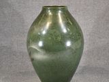 a green vase that is sitting on a table
