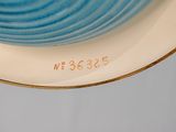 underside view of a blue and white plate with a gold rim