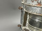 an old, rusted, metal light fixture with a glass lens