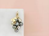 a close up of a pair of earrings with pearls on a marble block