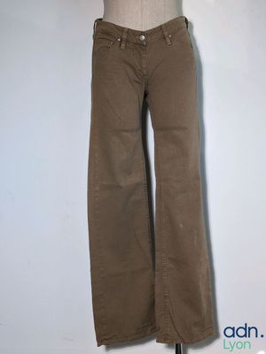 brown pants on a mannequin stand against a white wall