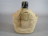 a bottle that is sitting on a table next to a bag