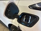 an electric car plugged in to a charging station with a blue light