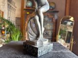a statue of a woman that is sitting on a table