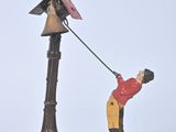 a figurine of a man holding an umbrella on a pole