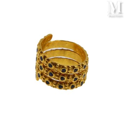 un gros plan d'une bague en or sertie de pierres noires