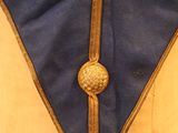 a close up of a blue and gold uniform with a gold button