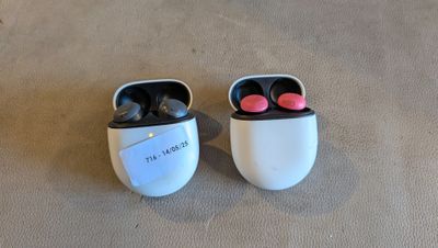 deux AirPods posés l'un à côté de l'autre sur le sol