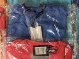 many different colored shirts in plastic bags on the table