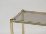 a glass table with a gold metal frame on it