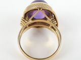 a close up of a ring with a purple stone in it