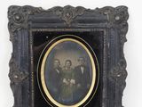 an old picture of a group of people in a black frame