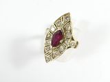 a close up of a ring with a red stone and diamonds