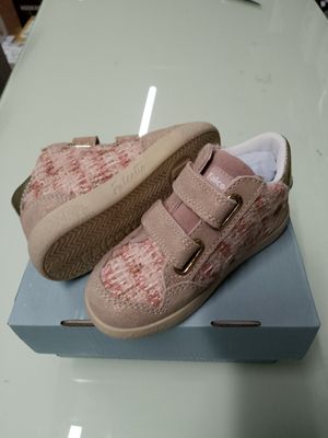une paire de chaussures de bébé posée sur une boîte, elle-même posée sur une table