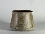 une photo d'un vase argenté posé sur une table blanche