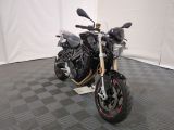 une moto qui est garée dans une pièce dont le sol est en damier
