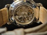 a close up of a watch with a leather band