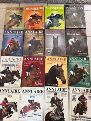 plusieurs livres posés par terre dans une pièce, sur lesquels figurent des chevaux et des jockeys