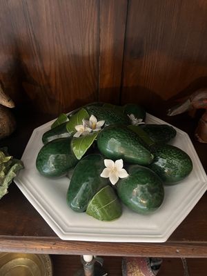 some cucumbers are on a white plate on a wooden shelf