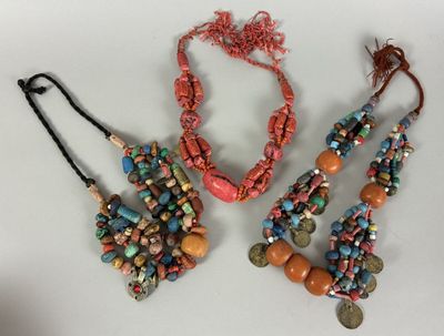 three necklaces and bracelets with different colored beads on a white surface