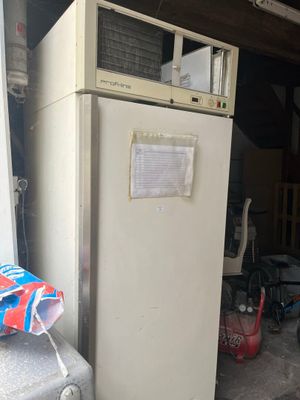 un réfrigérateur qui se trouve dans un garage, près d'une fenêtre