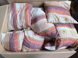 many pillows in a box on the floor