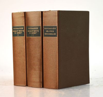trois livres superposés sur une surface blanche