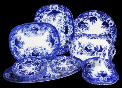 des assiettes, tasses et soucoupes bleues et blanches sur la table