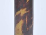 a brown and black vase sitting on top of a white table