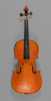 an old violin sitting on top of a table next to a gray wall