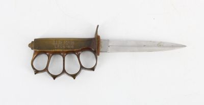 a small knife with a brass handle on a white surface