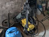 un aspirateur bleu et un bac bleu posés par terre