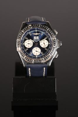 a close up of a watch on a black surface with a black background