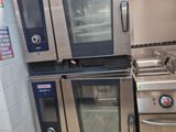 plusieurs fours et cuisinières en acier inoxydable dans une cuisine professionnelle