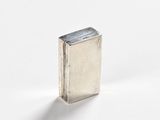 an image of a small silver book sitting on top of a white surface