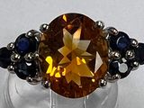 une bague ornée d'une grosse citrine entourée de saphirs bleus