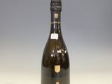 La bouteille de champagne est posée sur la table.