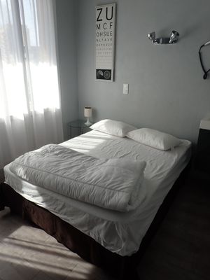 un lit recouvert d'une couette blanche et de draps blancs