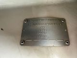 a metal plaque on the side of a white toilet